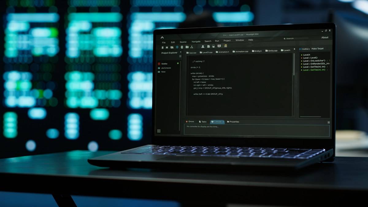 Ordinateur portable affichant un éditeur de code devant des baies de serveurs, l'environnement de travail d'un notebook Kaggle