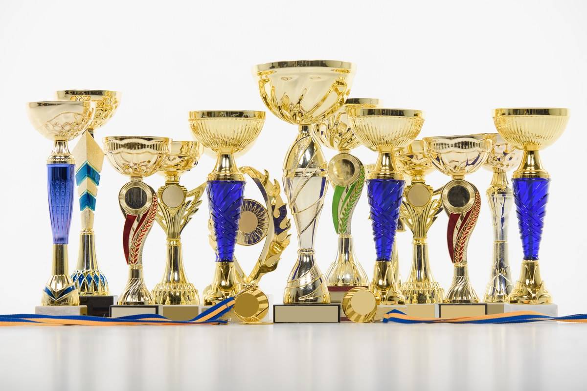 Coupes dorées et médailles alignées, symbole des classements des compétitions Kaggle