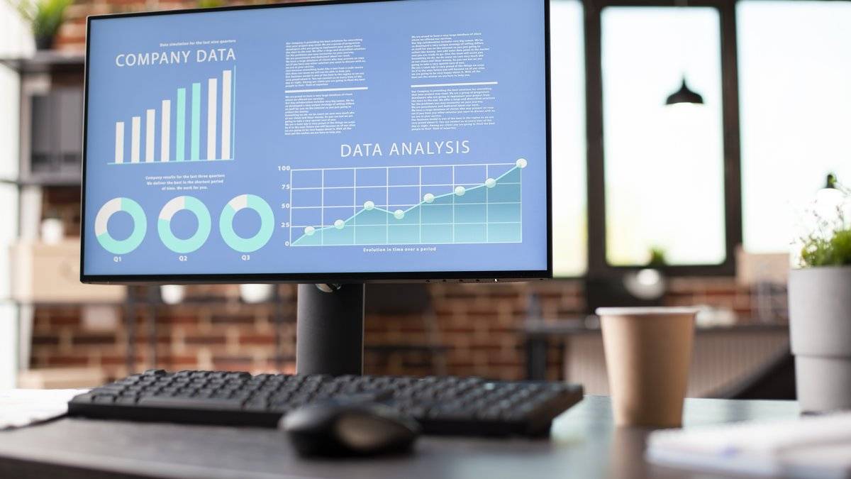 Écran d'ordinateur affichant des graphiques d'analyse de données sur un bureau vide, pour illustrer la data science sur Kaggle